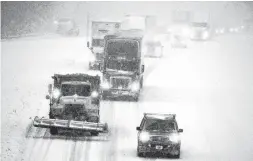  ?? H. Scott Hoffmann / Associated Press ?? Snow fell across the Southeast at rates of up to 2 inches per hour in some locations. Traffic moved slowly on open roads, while others were closed.