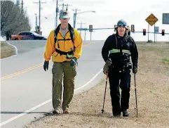  ?? [OKLAHOMAN ARCHIVE PHOTO] ?? Country music star Jimmy Wayne, right, and Army Lt. Col. Jason Garkey walk westward from McLoud on March 11, 2010, during Wayne’s Meet Me Halfway walk to raise awareness about homeless teens, especially those who age out of foster care.