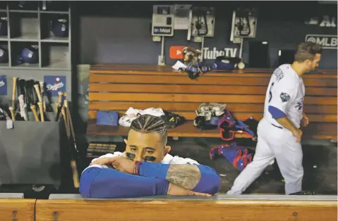  ??  ?? The Dodgers’ Manny Machado stands in the dugout after his team lost Game 5 of the World Series to the Red Sox on Sunday in Los Angeles. Boston won 5-1 to win the series 4 games to 1.