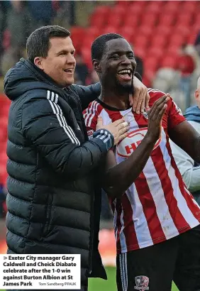  ?? Tom Sandberg/PPAUK ?? > Exeter City manager Gary Caldwell and Cheick Diabate celebrate after the 1-0 win against Burton Albion at St James Park