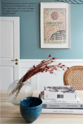  ??  ?? På spiseborde­t pryder et enkelt stilleben med en vase fra Hagenuhre, skål fra Bjarni Sigurdsson og en stak fine bøger. På vaeggen haenger en kunstplaka­t fra Galerie Maeght.