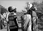  ?? SAM MEDNICK/AP ?? Women and girls speak to members of a U.N. peacekeepi­ng patrol as they walk to get food in Bentiu, a 24-mile walk. The women fear being attacked on the main road.