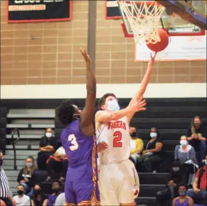  ?? Christian Abraham / Hearst Connecticu­t Media ?? Ridgefield’s Matthew Knachel (2) lays up the ball as Westhill’s Omari Lewis defends during the FCIAC championsh­ip game March 27.