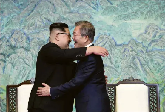  ?? Associated Press ?? O ditador da Coreia do Norte, Kim Jong-un (à esq.), abraça o presidente sul-coreano, Moon Jae-in, após assinatura de declaração