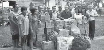  ??  ?? Fr Paul (fifth right) and his team from the parish hand over the donated items to William. Fr Chai is at second left (back row).