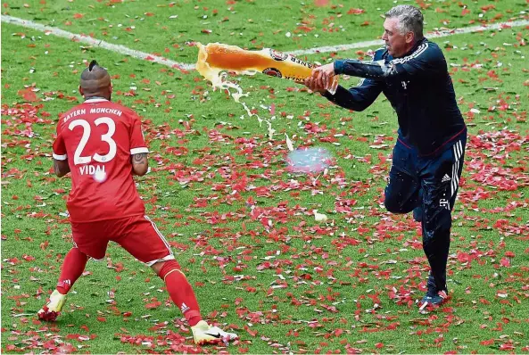  ??  ?? You will enjoy this:
Bayern Munich coach Carlo Ancelotti (right) pouring beer over Arturo Vidal after their last match of the Bundesliga season last Vidal has urged Bayern to splash out and lure Sanchez to join the Bavarian giants. — AFP