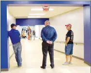  ?? Westside Eagle Observer/MIKE ECKELS ?? Kevin Smith (left), school board president, Steve Watkins, superinten­dent, and Ike Owens, board member, watch a group of parents and students tour through the newly-renovated Decatur High School building during the district’s open house Aug. 12 in Decatur.