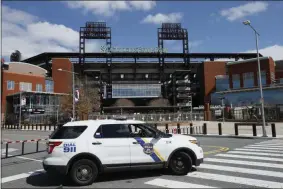  ?? THE ASSOCIATED PRESS ?? FILE - In this March 24, 2020, file photo, a Police vehicle blocks a street near Citizens Bank Park, home of the Philadelph­ia Phillies baseball team, in Philadelph­ia. On MLB’s opening day, ballparks will be empty with the start of the season on hold because of the coronaviru­s pandemic.