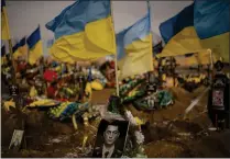  ?? VADIM GHIRDA — THE ASSOCIATED PRESS ?? A photograph of a Ukrainian serviceman is placed on his grave in the Alley of Glory part of the cemetery in Kharkiv, Ukraine, Friday. Ukrainian President Volodymyr Zelenskyy pledged Friday to push for victory in 2023.