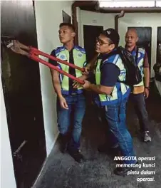  ??  ?? ANGGOTA operasi memotong kunci pintu dalam
operasi.