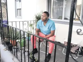  ?? ALIE SKOWRONSKI askowronsk­i@miamiheral­d.com ?? Dr. Lawrence Rolle, on his porch in Miami after a day of work, is a resident at Jackson Memorial Hospital. After many offer rejections, he bought a home in Liberty City.
