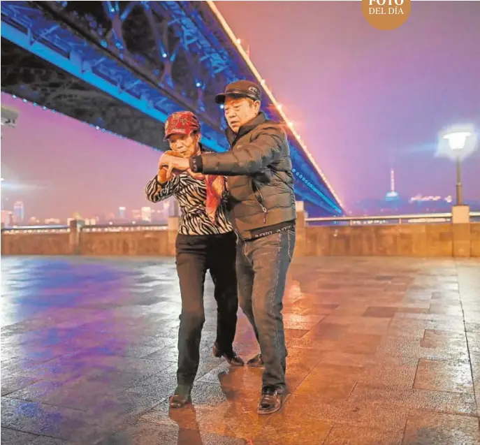  ?? AFP ?? Una pareja de ancianos baila
ayer bajo un puente sobre el río Yangtsé, en
la ciudad de Wuhan, donde hace ahora un año se declaró
el brote de coronaviru­s