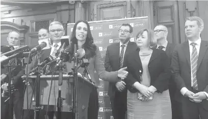  ?? — Gambar Reuters ?? TEGAS: Ardern (tengah) bercakap kepada media sambil diperhatik­an anggota parti di Wellington, kelmarin.