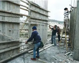  ?? (Ammar Awad/Reuters) ?? PALESTINIA­N LABORERS work at a constructi­on site in the settlement of Ramat Givat Ze’ev, near Jerusalem, earlier this month.