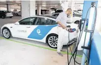  ?? THOMAS WINTER/COURTESY ?? A man uses the FPL EV Brightline Parking Garage charging station in West Palm Beach on Sept. 23, 2019.