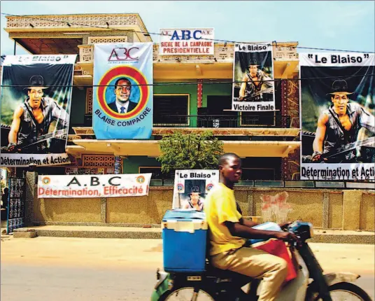  ?? KATRINA MANSON/REUTERS ?? Election posters in Ouagadougo­u show Burkina Faso President Blaise Compaoré superimpos­ed over the torso of popular action hero Indiana Jones.