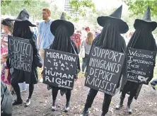  ?? STAFF PHOTO BY CHRIS CHRISTO ?? ‘OUTRAGED’: People dressed as faceless witches show their support for immigrants at the DACA rally on the Common.