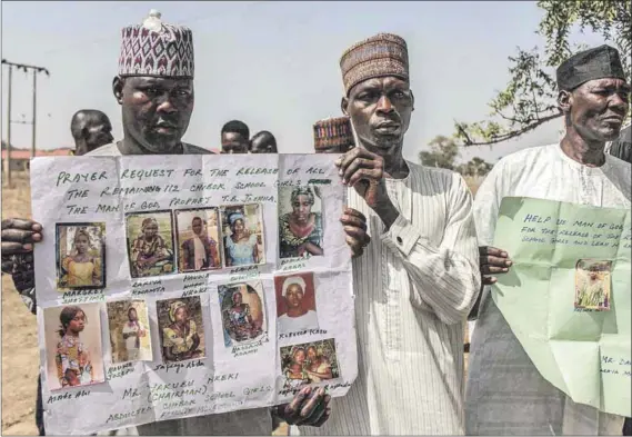 ?? Photos: Audu Ali Marte/afp and AFP ?? Untold torment: Relatives hold portraits (above) of schoolgirl­s still missing after they were kidnapped in 2014. The image (left) taken from a Youtube video in 2016 purportedl­y shows the girls.
