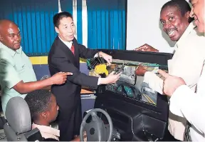  ?? PHOTOS BY ORANTES MOORE ?? From left: Sheldon Kidd; Chinese Ambassador to Jamaica Niu Qingbao; and the member of parliament for Western St Mary, Robert Montague, at a ceremony to hand over a driving simulator to the principal of Oracabessa High School, Paul Lofters.