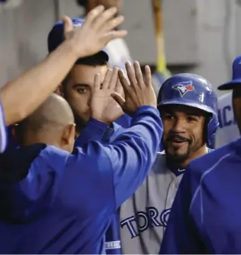  ?? MATT MARTON/THE ASSOCIATED PRESS ?? Devon Travis is congratula­ted by teammates after scoring on a Josh Donaldson double in a four-run third inning Wednesday night. The game ended too late for this edition of the paper. For full coverage, visit thestar.com/sports.