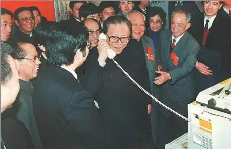  ?? PHOTOS BY XINHUA NEWS AGENCY ?? Jiang Zemin tries out an internatio­nal call to greet workers while visiting the Beijing Exhibition Hall in May 1984. New electronic­s products were being showcased at the event.