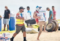  ?? MALAU MEDIA/IFRC ?? Tonga Red Cross Society’s staffers and volunteers unload boxes of noodles from the boat onto the beach April 1 in Nomuka on Ha’apai Island, Tonga.