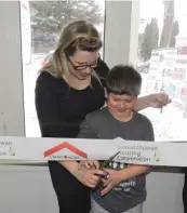  ??  ?? Kathy and her son Carter cut the ribbon to their brand-new home.