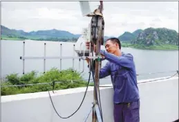  ?? PROVIDED TO CHINA DAILY ?? Yin Shanyong, a 50-year-old caretaker of the Guantang reservoir in Liujiang county, Guangxi Zhuang autonomous region, cleans monitoring equipment at the reservoir on Sunday.