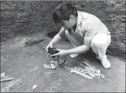  ?? PROVIDED TO CHINA DAILY ?? Zooarchaeo­logist Hu Songmei photograph­s a skeleton at a tomb in Xi’an, Shaanxi province, where she and colleagues found the bones of an extinct gibbon.