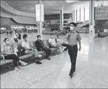  ?? TIAN XI / FOR CHINA DAILY ?? A staff member reminds passengers to keep distance at Lanzhouxi Railway Station in Lanzhou, Gansu province, on Friday.