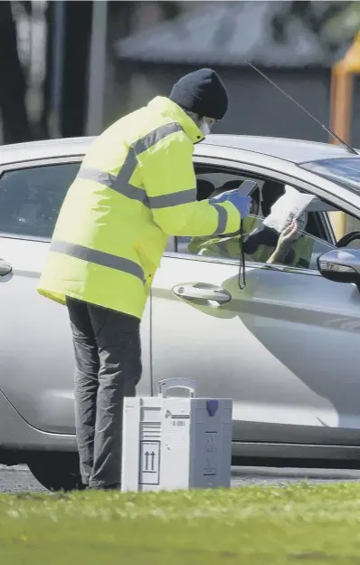  ??  ?? 0 Members of the public get tested for coronaviru­s at a mobile testing centre in West Dunbartons­hire after lockdown measures were imposed in Glasgow and other parts of the west of Scotland this week