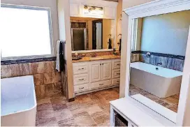  ?? CHRIS LANDSBERGE­R, THE OKLAHOMAN] [PHOTOS BY ?? Above and below: The master bath and kitchen in the Jim Campbell home at 3208 Drake Crest Drive. The kitchen is complete with a breakfast bar and walk-in pantry.