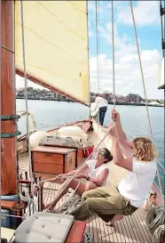  ?? PHOTOS BY SEAN D. ELLIOT/THE DAY ?? Left, Capt. Seth Salzmann, right, and deckhand Jenny Carcos, raise the staysail as deckhand Kayla Lang prepares the ship’s jib sail