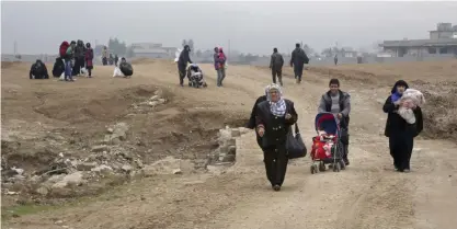  ??  ?? MOSUL: Civilians flee their neighborho­ods due to fighting between Iraqi security forces and Islamic State militants, in eastern Mosul, Iraq, yesterday.