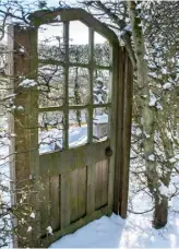  ??  ?? THIS PAGE, TOP The fine detailing of the clipped knot garden is highlighte­d by a dusting of snow ABOVE Within the hornbeam hedge enclosure is a decorative rustic oak gate OPPOSITE The yews stand sentinel, forming a strong east-west axis across the garden