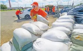  ?? AP PHOTO/MATTHEW HINTON ?? St. Bernard Parish Sheriff’s Office inmate workers move free sandbags for residents in Chalmette, La., on Thursday ahead of Tropical Storm Barry from the Gulf of Mexico.