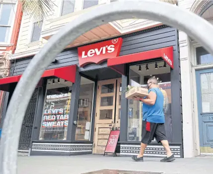  ?? GETTY IMAGES/AFP ?? A pedestrian walks by a Levi’s store in San Francisco on Wednesday.