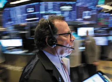  ??  ?? A trader works on the floor of the New York Stock Exchange