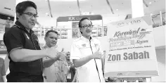  ??  ?? Masidi (right), accompanie­d by Kamel (left) and Ismail (centre), at the 2018 KPTN launch at 1Borneo Hypermall yesterday.