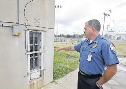  ??  ?? Chief of Security Chad Gilley talks about maintenanc­e issues at the Oklahoma State Penitentia­ry in McAlester. Gilley points out holes drilled in a window frame to allow airflow, a result of no air conditioni­ng on the maximum security unit.