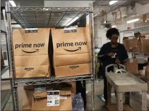  ?? Associated Press/MARK LENNIHAN ?? An Amazon worker photo. sorts Prime Now customer orders in a warehouse in New York in this 2017 file