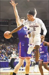  ?? Stephen Dunn / Associated Press ?? UConn's Tarin Smith passes the ball around UMass Lowell’s Connor Bennett Tuesday night.