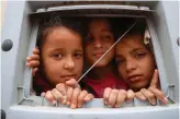  ?? AFP ?? Displaced children peak from inside a classroom at a makeshift school in the village of Haranabush in Syria’s northweste­rn
Idlib province on Saturday.