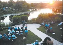  ??  ?? Patrons listen to classical music Wednesday as the sun sets at Lake Katherine’s Sunset Sonata.