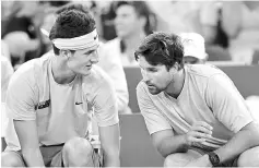  ??  ?? File photo of Bernard Tomic (left) of Australia talking with coach Pat Rafter during his men’s singles Davis Cup match. — AFP photo