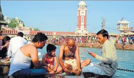  ?? RAMESHWAR GAUR/HT PHOTO ?? A family performs ash immersion rituals at Subash Ghat,which is being objected to by Ganga Sabha; (right) A man immerses the ashes of his relative in the Ganga.