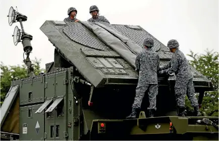  ?? PHOTO: REUTERS ?? Japan Self-defence Forces soldiers hold a drill to mobilise their Patriot Advanced Capability-3 missile unit in response to recent missiles launch by North Korea.