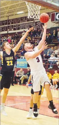  ?? Westside Eagle Observer/RANDY MOLL ?? Gentry senior guard Gavin Taylor shoots under the basket while guarded by Prairie Grove senior Nick Pohlman during Friday’s basketball coronation game at Gentry High School. RANDY MOLL rmoll@nwadg.com