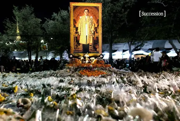  ??  ?? ABOVE: A blanket of flowers from his mourning subjects flanks a portrait of the late King Bhumibol in Bangkok.