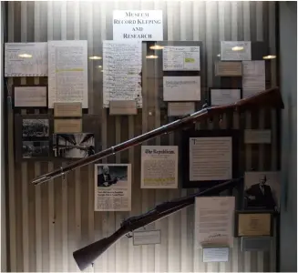  ??  ?? 博物馆早期文档和历史­图片，其中有博物馆收藏的带­有士兵个性化铭刻的恩­菲尔德步枪（上）和序列号为“1”的M1903原型枪（下）